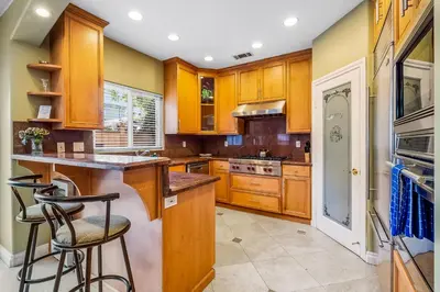 a kitchen with wooden cabinets and bar stools at The Shangri-La of La Jolla in San Diego