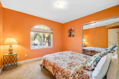 a bedroom with orange walls and a large mirror at The Shangri-La of La Jolla in San Diego