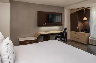 a hotel room with a bed and a desk with a television at Courtyard by Marriott Temecula Murrieta in Murrieta
