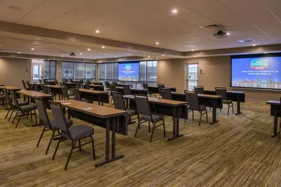 a conference room with tables and chairs and a large screen at Courtyard by Marriott Temecula Murrieta in Murrieta