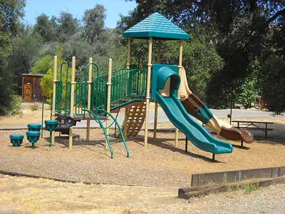 a playground with a slide in a park at Oakzanita Springs Camping Resort Cabin 1 in Descanso
