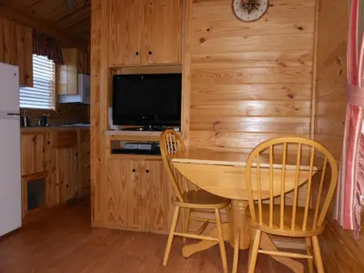 a kitchen with a table and two chairs and a television at Oakzanita Springs Camping Resort Cabin 2 in Descanso