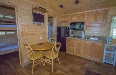 a kitchen with a wooden table and chairs in a cabin at Oakzanita Springs Camping Resort Cottage 3 in Descanso