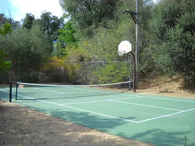 a tennis court with a net and a basketball hoop at Oakzanita Springs Camping Resort Cottage 4 in Descanso