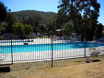 a fence around a swimming pool with a swimming pool at Oakzanita Springs Camping Resort Cottage 4 in Descanso