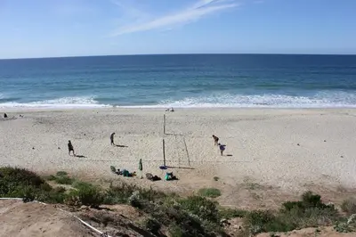 a group of people playing volleyball on a beach at Seaside Village Carlsbad in Carlsbad