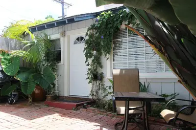 a white garage with a door with plants on it at La Jolla Cottage in San Diego