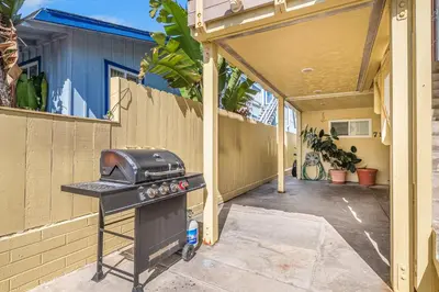 a barbecue grill in a backyard with a fence at Mike's Place at the Beach in San Diego