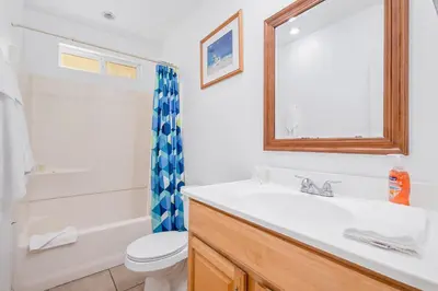a bathroom with a sink and a toilet and a mirror at Mike's Place at the Beach in San Diego