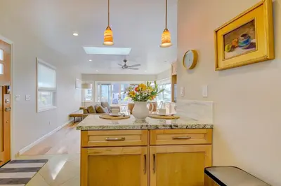 a kitchen with a center island with a vase of flowers at Beach Park Getaway in San Diego