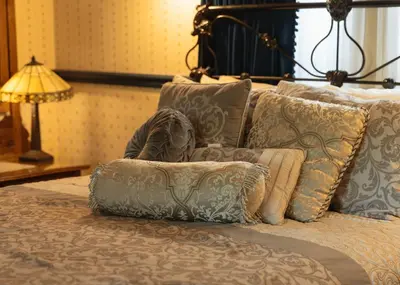 a bedroom with a bed with pillows and a lamp at Julian Gold Rush Hotel in Julian