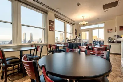 a restaurant with tables and chairs and large windows at Gaslamp Plaza Suites in San Diego
