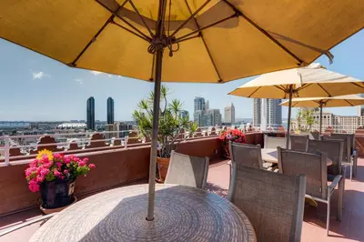 a table with an umbrella on top of a balcony at Gaslamp Plaza Suites in San Diego