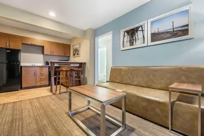 a living room with a couch and a kitchen at Best Western Carlsbad by the Sea in Carlsbad