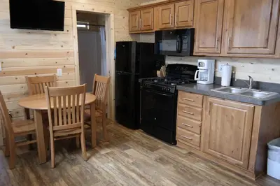 a kitchen with a table and a stove and refrigerator at Pio Pico Camping Resort Cottage 1 in Jamul