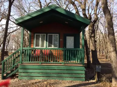 a small green house in the middle of trees at Pio Pico Camping Resort Studio Cabin 7 in Jamul