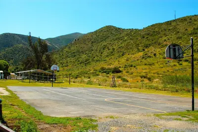 an empty parking lot with mountains in the background at Pio Pico Camping Resort Two-Bedroom Cabin 12 in Jamul