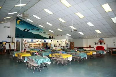 a cafeteria with tables and chairs in a room at Pio Pico Camping Resort Two-Bedroom Cabin 12 in Jamul