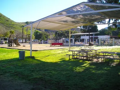 a group of picnic tables under a white canopy at Pio Pico Camping Resort One-Bedroom Cabin 13 in Jamul