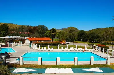 a large swimming pool with chairs and a resort at Pio Pico Camping Resort One-Bedroom Cabin 13 in Jamul
