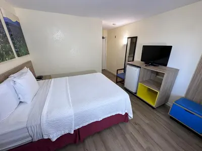 a hotel room with a bed and a flat screen tv at Days Inn by Wyndham San Marcos in San Marcos