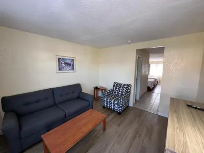 a living room with a blue couch and a chair at Days Inn by Wyndham San Marcos in San Marcos