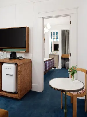 a hotel room with a television and a table and a room at Palihotel San Diego Gaslamp Quarter in San Diego