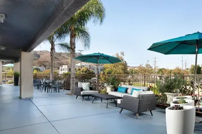 a patio with tables and chairs and umbrellas at Signature Temecula in Temecula