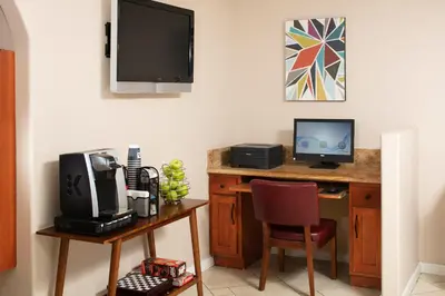a room with a desk with a computer and a television at Signature Temecula in Temecula