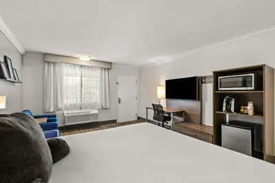 a hotel room with a large bed and a flat screen tv at Signature Temecula in Temecula