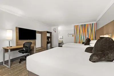 a hotel room with two beds and a desk and a tv at Signature Temecula in Temecula