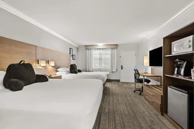 a hotel room with two beds and a desk at Signature Temecula in Temecula