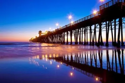 a pier with lights on the beach at night at Beachside Retreat in Oceanside