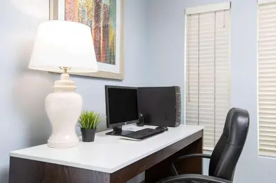a desk with a computer and a lamp on it at Baymont by Wyndham San Diego Downtown in San Diego
