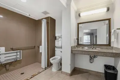 a bathroom with a toilet and a sink and a mirror at Motel 6 Carlsbad, Ca- North in Carlsbad