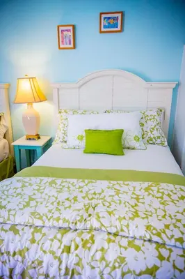 a bedroom with a white bed with a green pillow at Leucadia Beach Inn in Encinitas