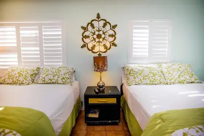 a bedroom with two beds and a lamp on a night stand at Leucadia Beach Inn in Encinitas
