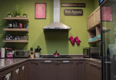 a kitchen with green walls and a stove top oven at California Dreams Hostel - Pacific Beach in San Diego