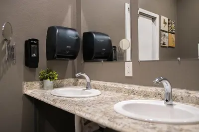 a bathroom counter with two sinks and a mirror at California Dreams Hostel - Pacific Beach in San Diego