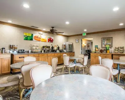 a room with tables and chairs and a kitchen at Quality Suites San Diego Otay Mesa in Otay Mesa