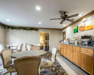 a dining room with a table and chairs and a kitchen at Quality Suites San Diego Otay Mesa in Otay Mesa
