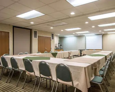 a conference room with tables and chairs and a screen at Quality Suites San Diego Otay Mesa in Otay Mesa