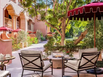 a patio with chairs and tables and an umbrella at Fairmont Grand Del Mar in San Diego