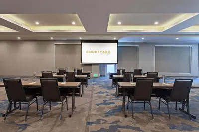 a conference room with tables and chairs and a projection screen at Courtyard by Marriott San Diego El Cajon in El Cajon