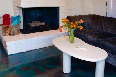 a living room with a table and a couch and a fireplace at Sweet Beach Duplex in Newport Beach