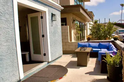 a patio with a blue couch and a table at Sweet Beach Duplex in Newport Beach