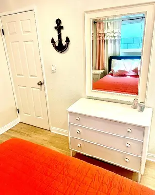 a bedroom with a dresser and a large mirror at Sweet Beach Duplex in Newport Beach