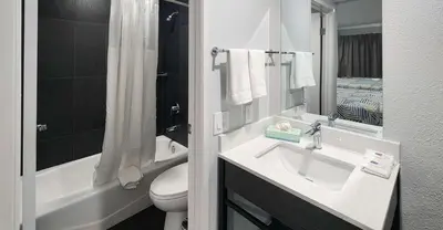 a white bathroom with a sink and a toilet at Studio 6 Suites San Ysidro CA San Diego South Bay in San Ysidro, San Diego