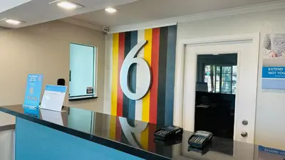 an office lobby with a large sign on the wall at Studio 6 Suites San Ysidro CA San Diego South Bay in San Ysidro, San Diego