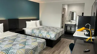 a hotel room with two beds and a sink at Studio 6 Suites San Ysidro CA San Diego South Bay in San Ysidro, San Diego